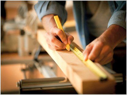 contractor measuring wood material