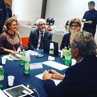 Un gruppo di persone è seduto attorno a un tavolo e sta tenendo una riunione.