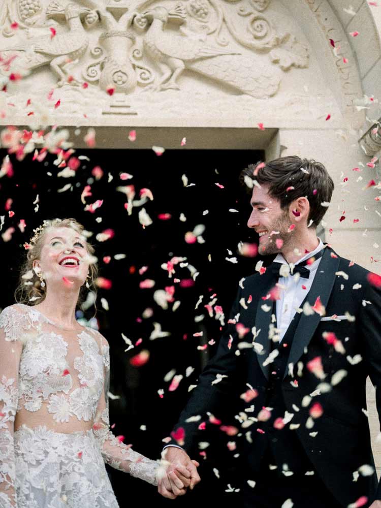 Mariés sous une pluie de confettis de pétales à la sortie de la cérémonie