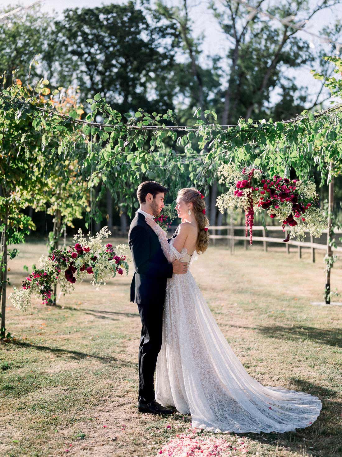 Couple de mariés dans les jardins du Château de Varennes avec confettis de pétales
