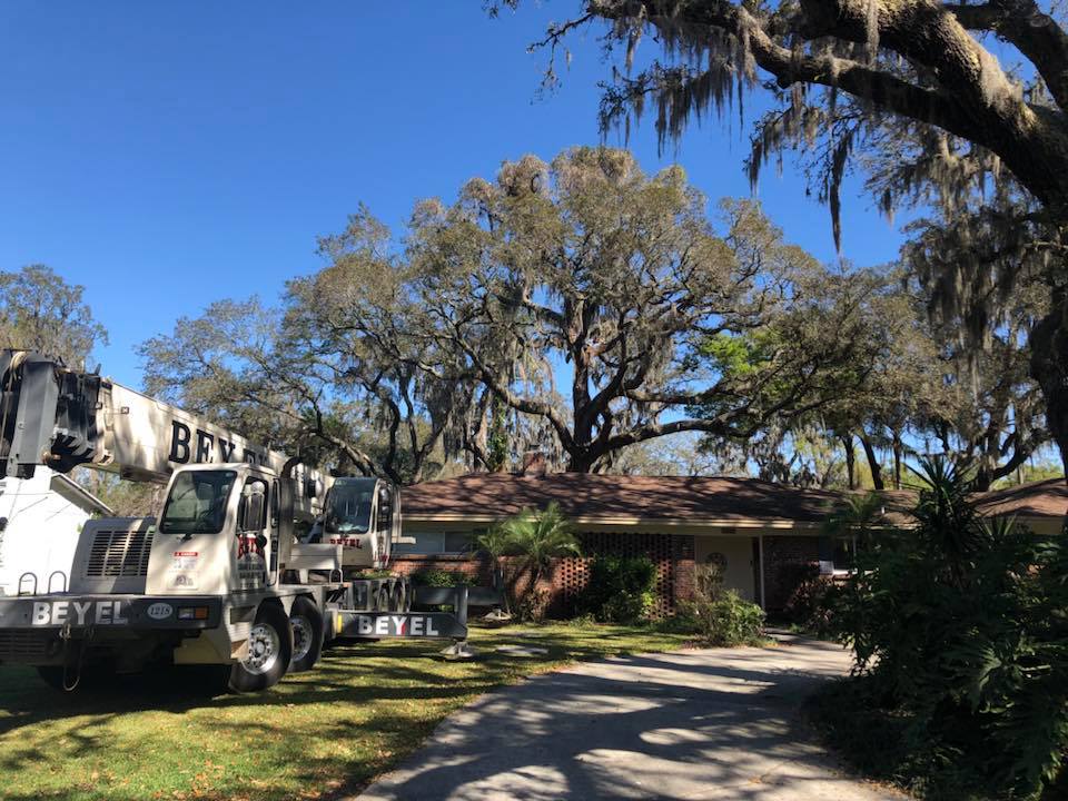 A Crane Truck Beside A Residential House — Tampa, FL — A Baker's Tree Service