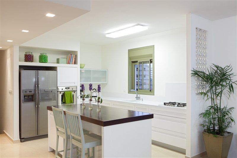 A kitchen with white cabinets and a stainless steel refrigerator featuring places for rent and homes in the Southeastern Michigan area.
