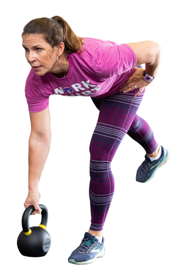A woman in a pink shirt and purple leggings is holding a kettlebell.