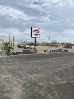 Parking lot beside a U-Haul store sign under a cloudy sky