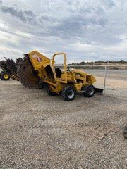 Yellow construction equipment on a gravel lot under a cloudy sky