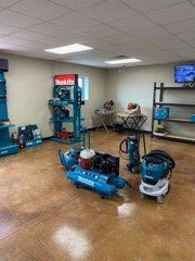 Industrial equipment showroom with blue air compressors and tools on display
