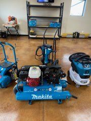 Blue Makita air compressor and other tools in a garage workshop