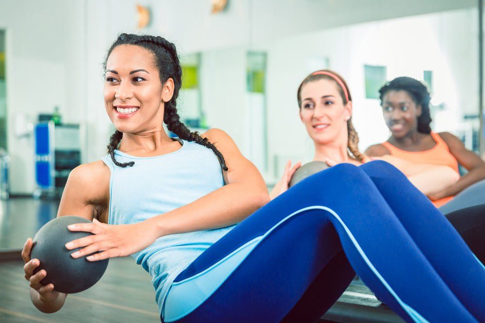 Woman Doing Russian Twist With Med Ball — Longmont, CO — Longmont Athletic Club