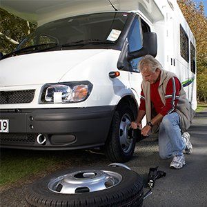RV Body Repair Services — Man Fixing Tire in Santa Cruz,CA RV Body Repair Services — Man Fixing Tire in Santa Cruz,CA