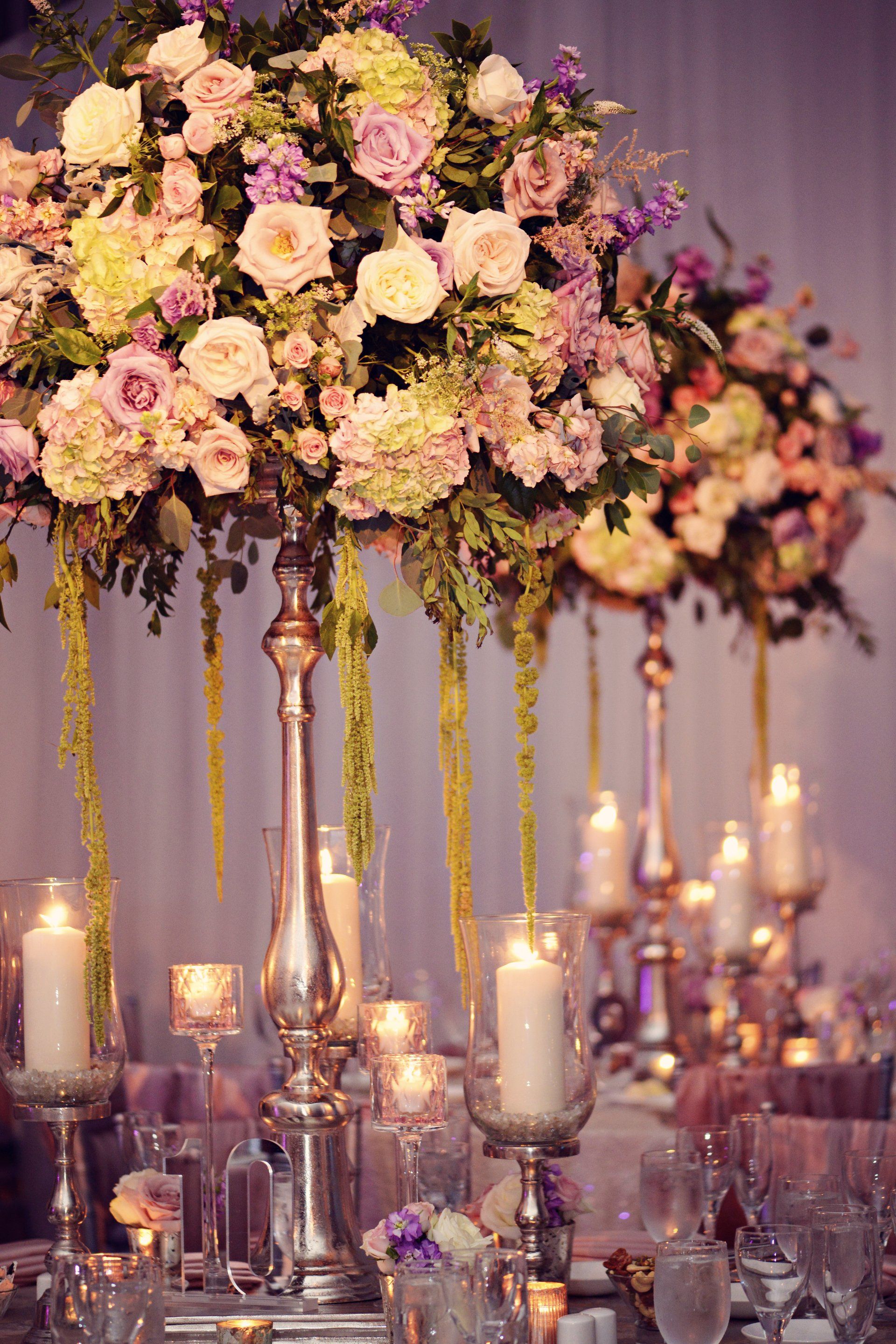 A table decorated with flowers and candles for a wedding reception.