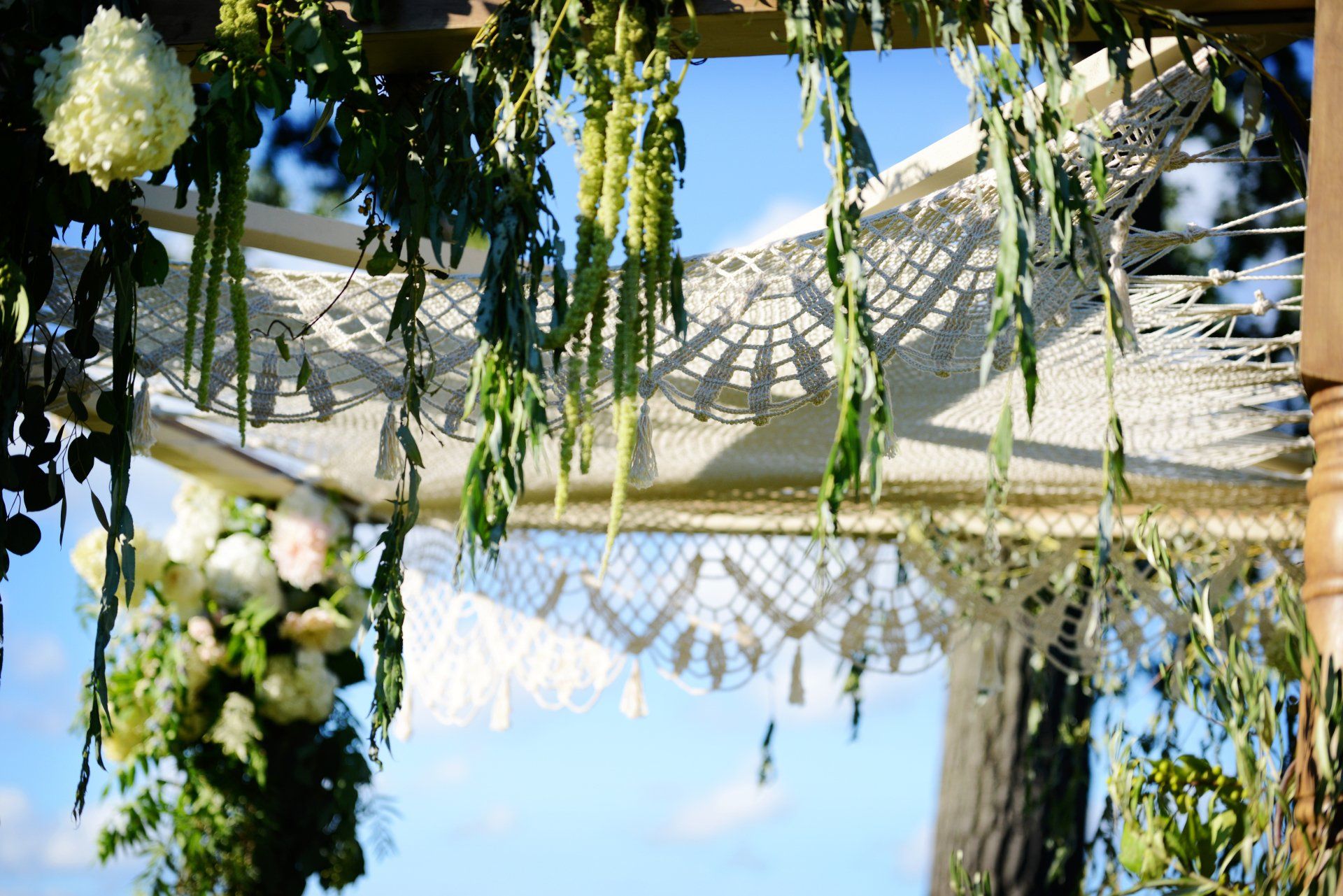 A wedding arch with flowers and leaves hanging from it