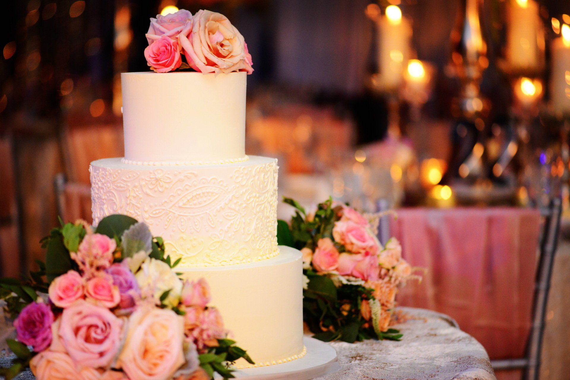 A wedding cake with flowers on top of it is sitting on a table.