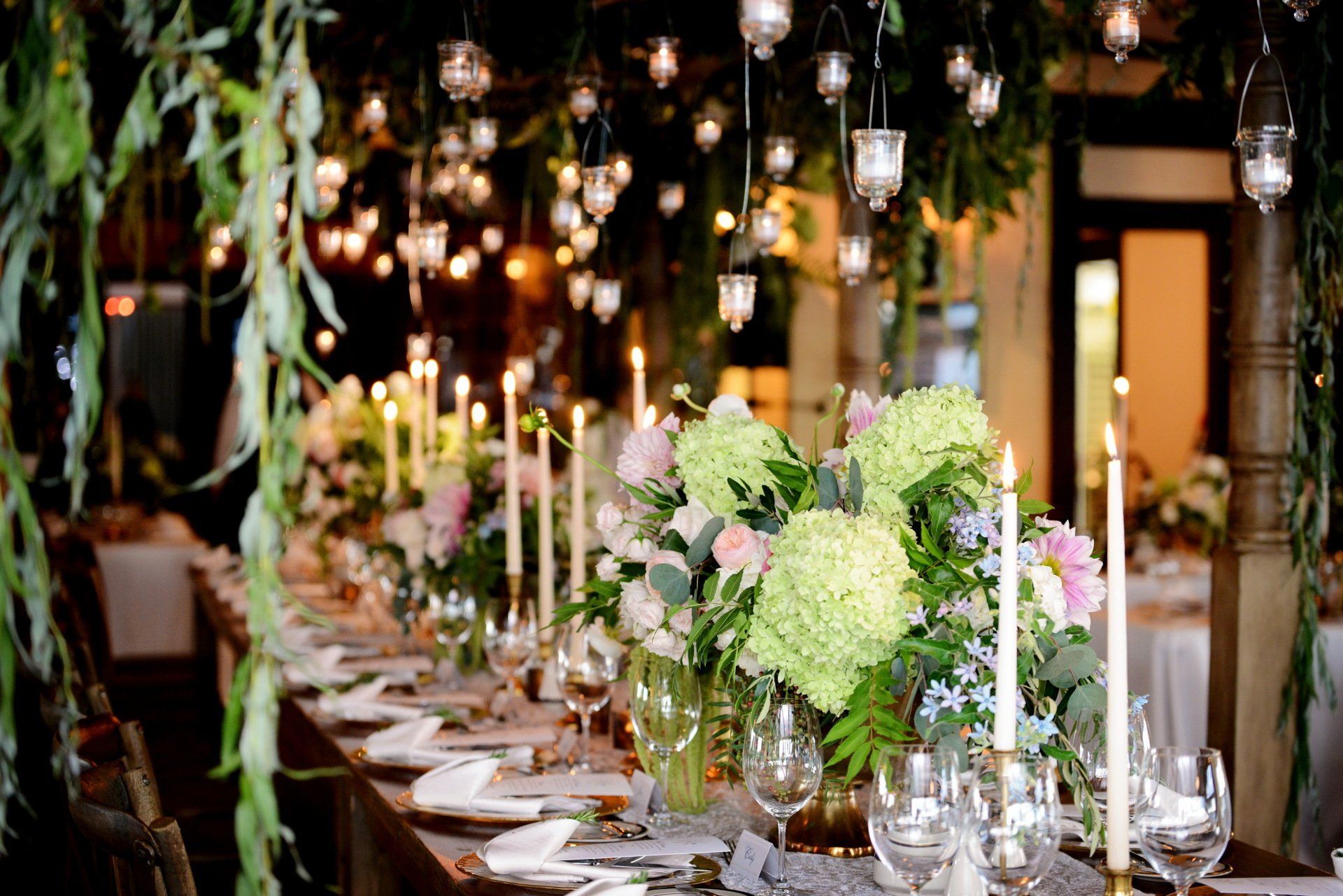 A long table with candles and flowers on it.