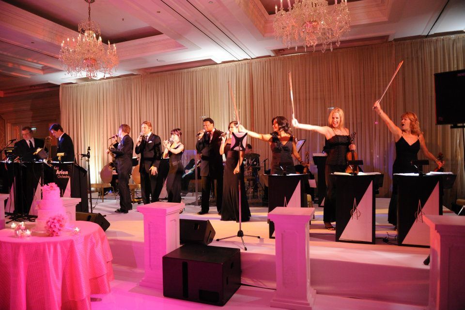 A group of people are standing on a stage playing instruments.