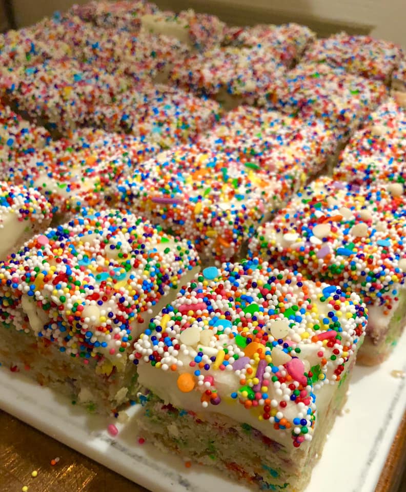 A bunch of slices of cake with sprinkles on them