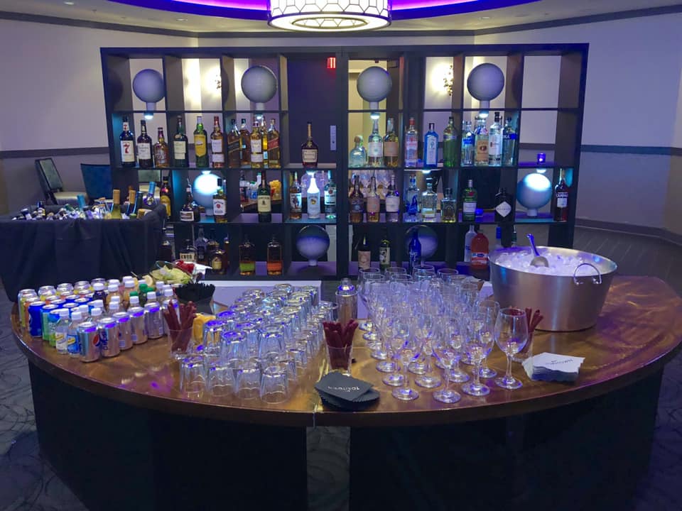 A round table with a lot of glasses and cans on it
