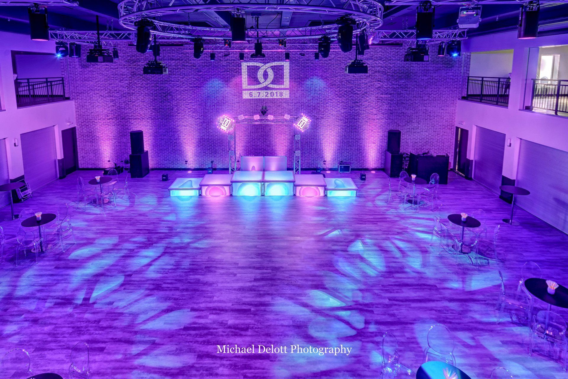 An aerial view of a dance floor in a large room with purple lights.