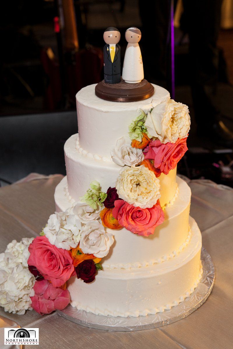 A wedding cake with a bride and groom figurine on top