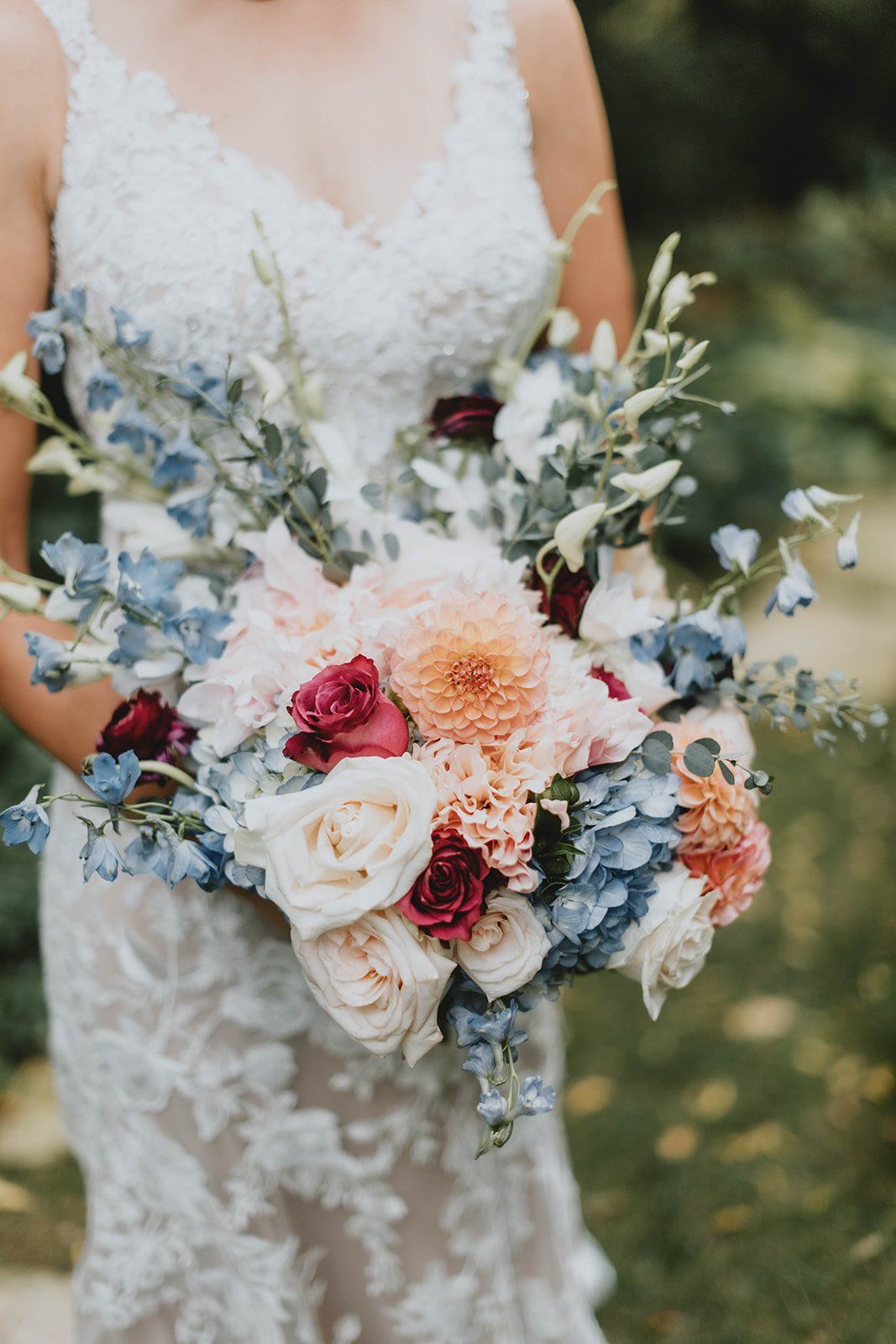 A bride in a wedding dress is holding a bouquet of flowers.