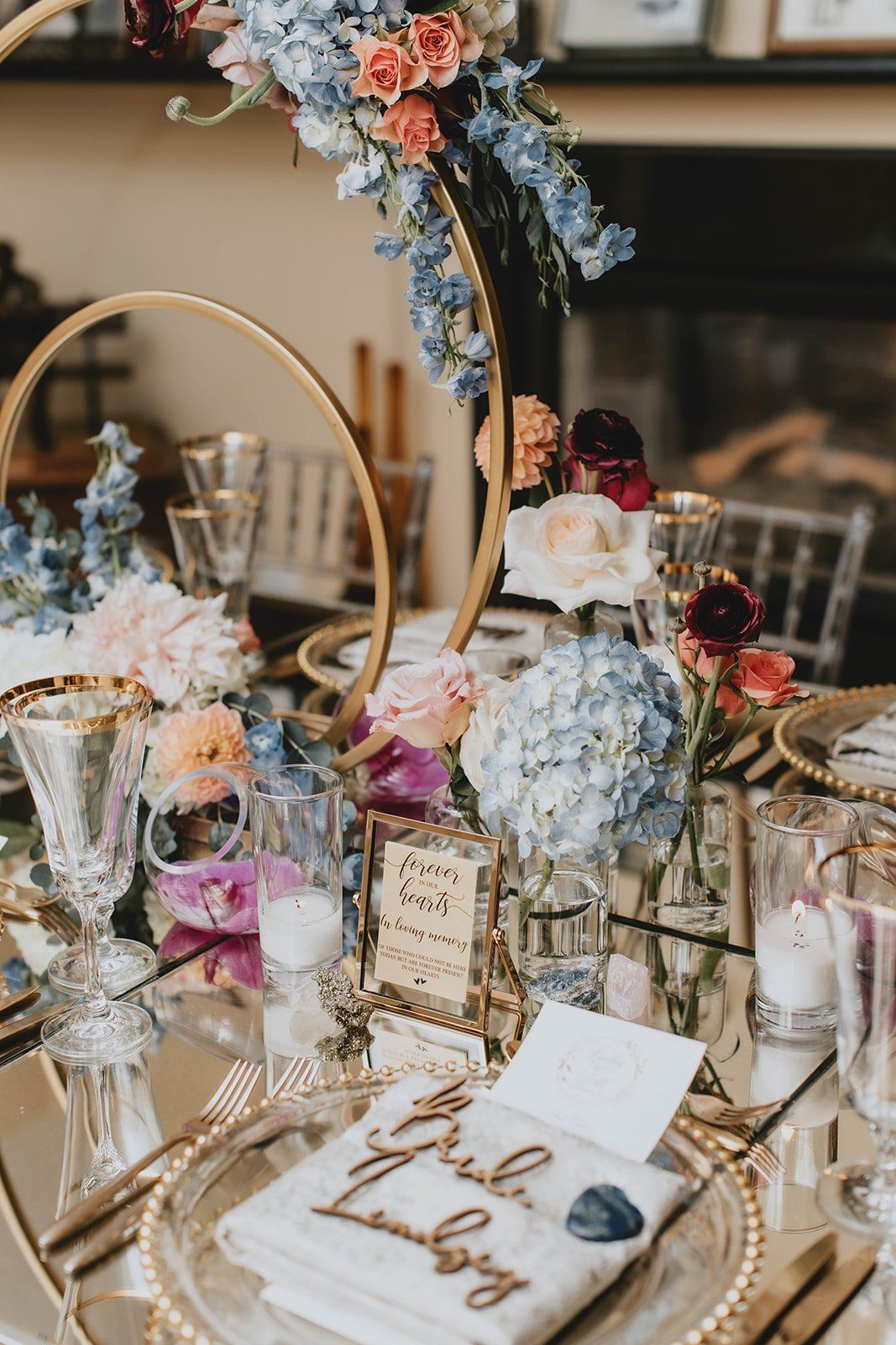 A table with plates , glasses , candles , and flowers on it.