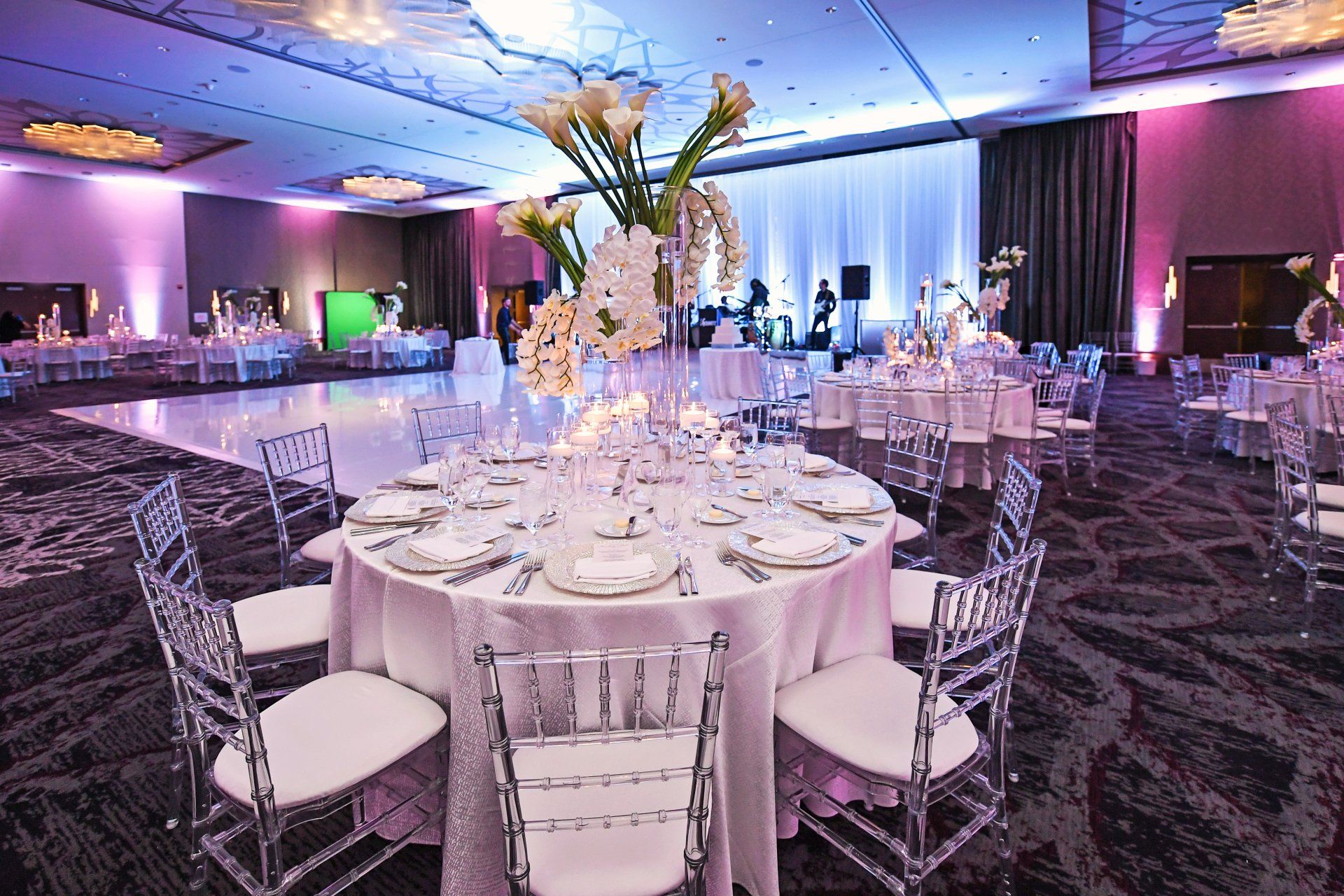 A large room with tables and chairs set up for a wedding reception.