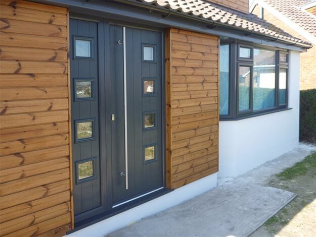 A house with a black door and wooden siding