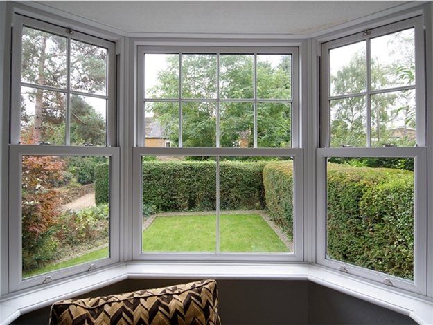A living room with a large window looking out to a garden.