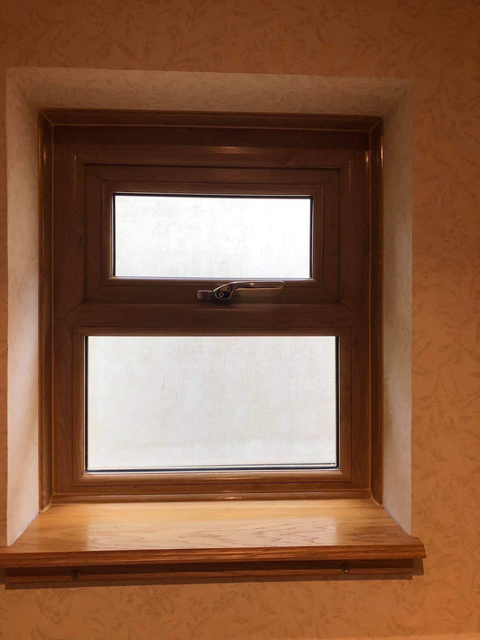 A window with a wooden frame and a wooden sill