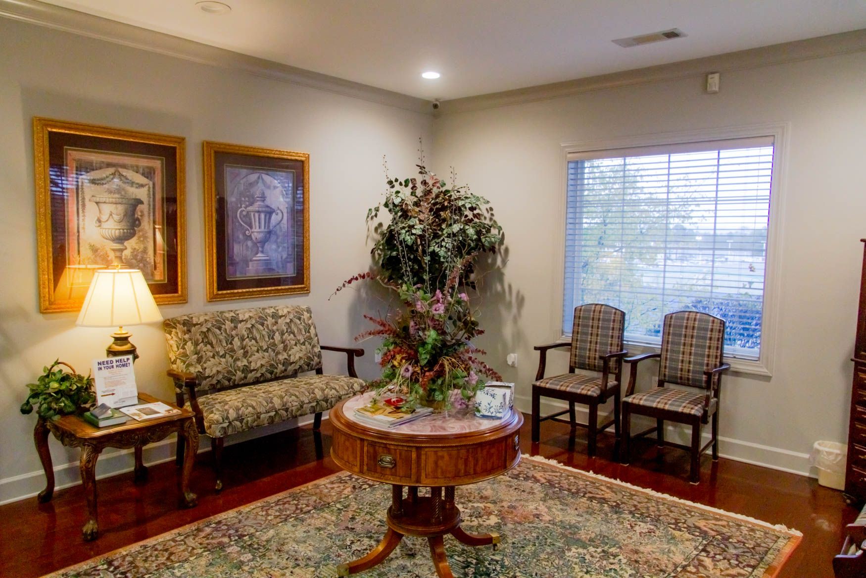 A waiting room with a table , chairs , and a couch.