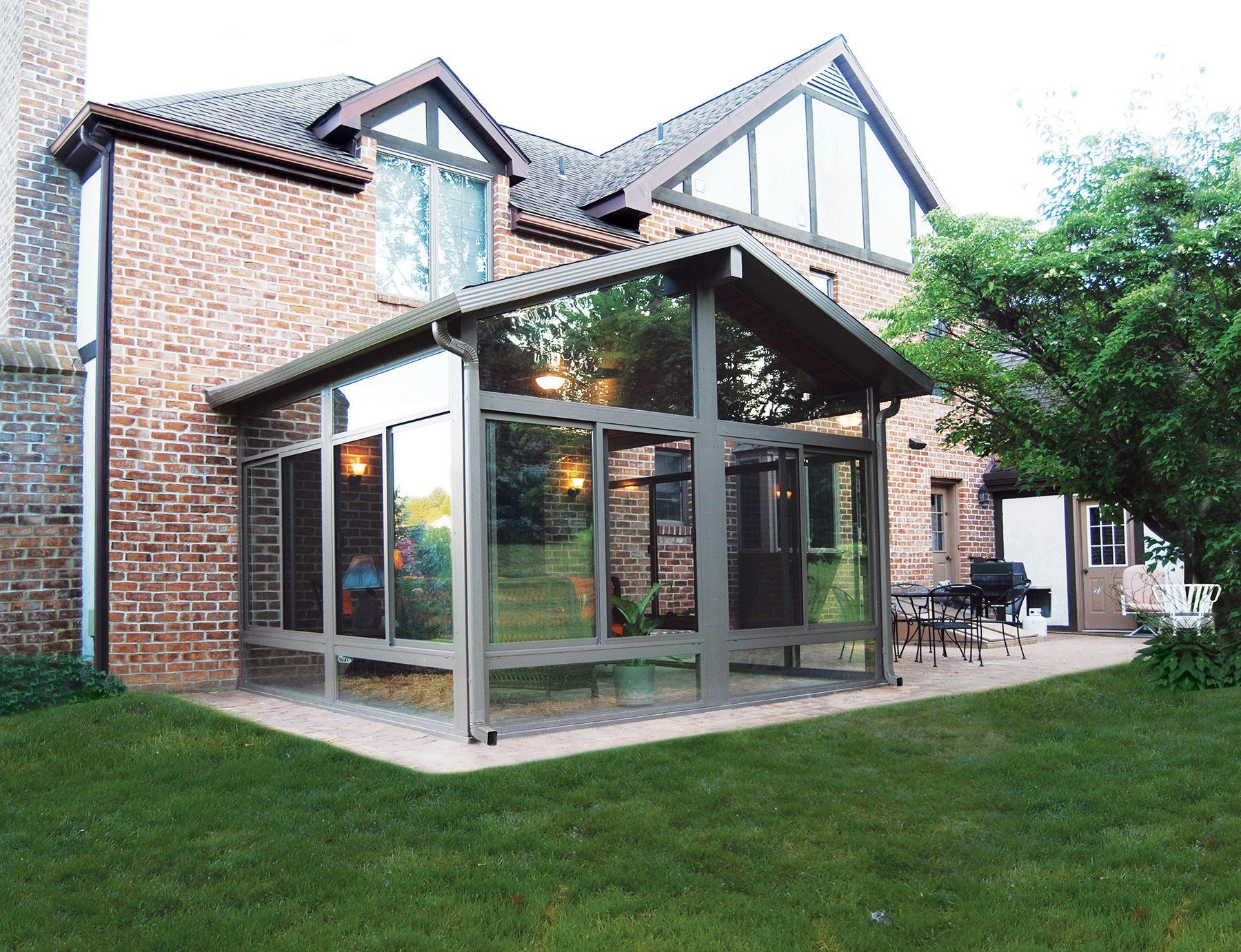 A brick house with a large glass covered porch