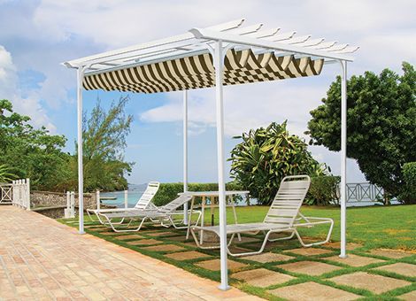 A white pergola with a striped awning and chairs underneath it
