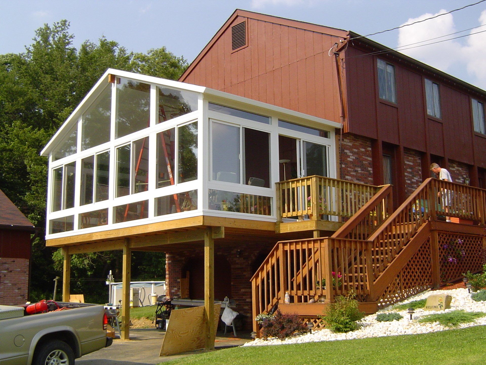 A truck is parked in front of a house with a deck