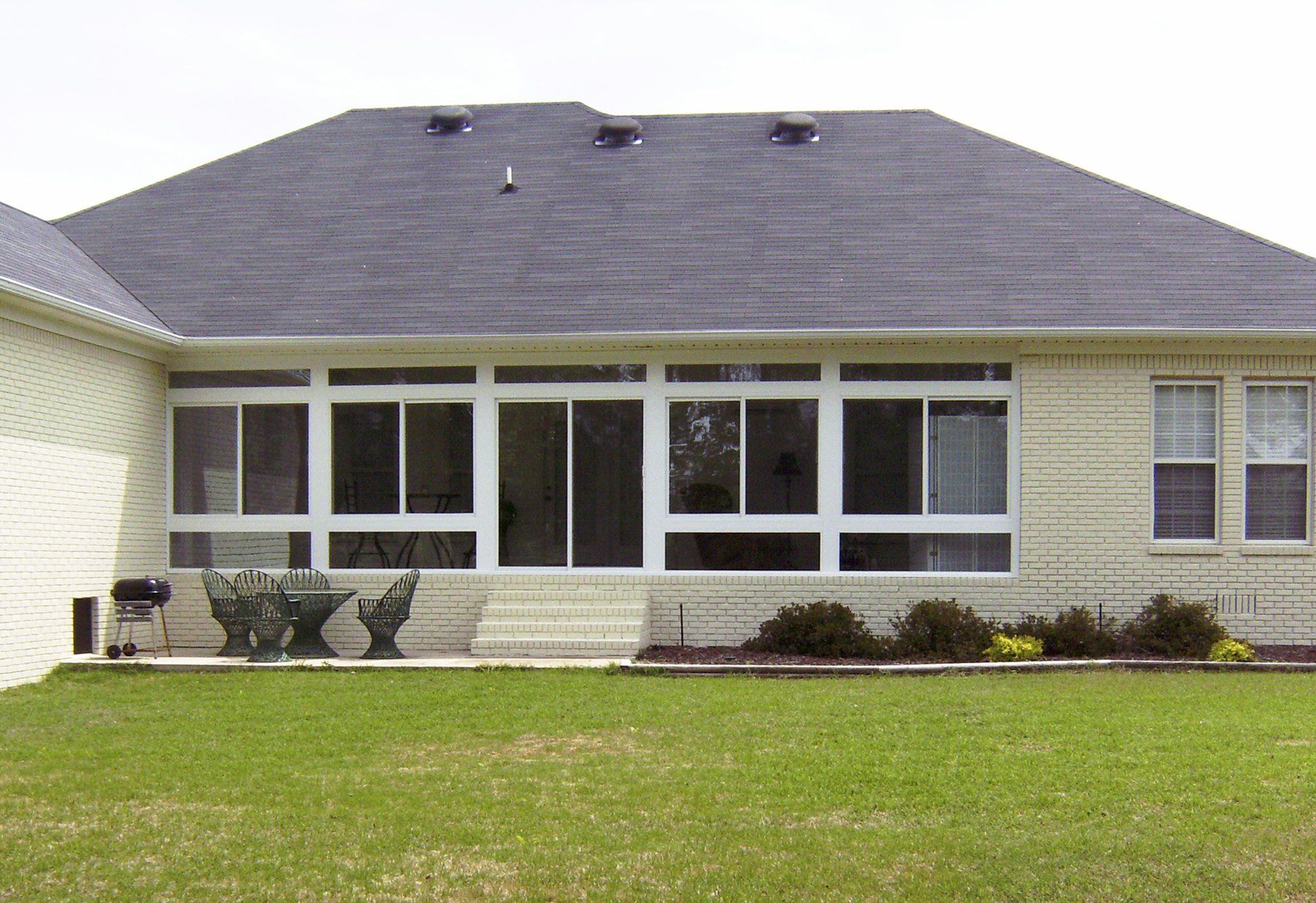 The back of a house with a screened in porch