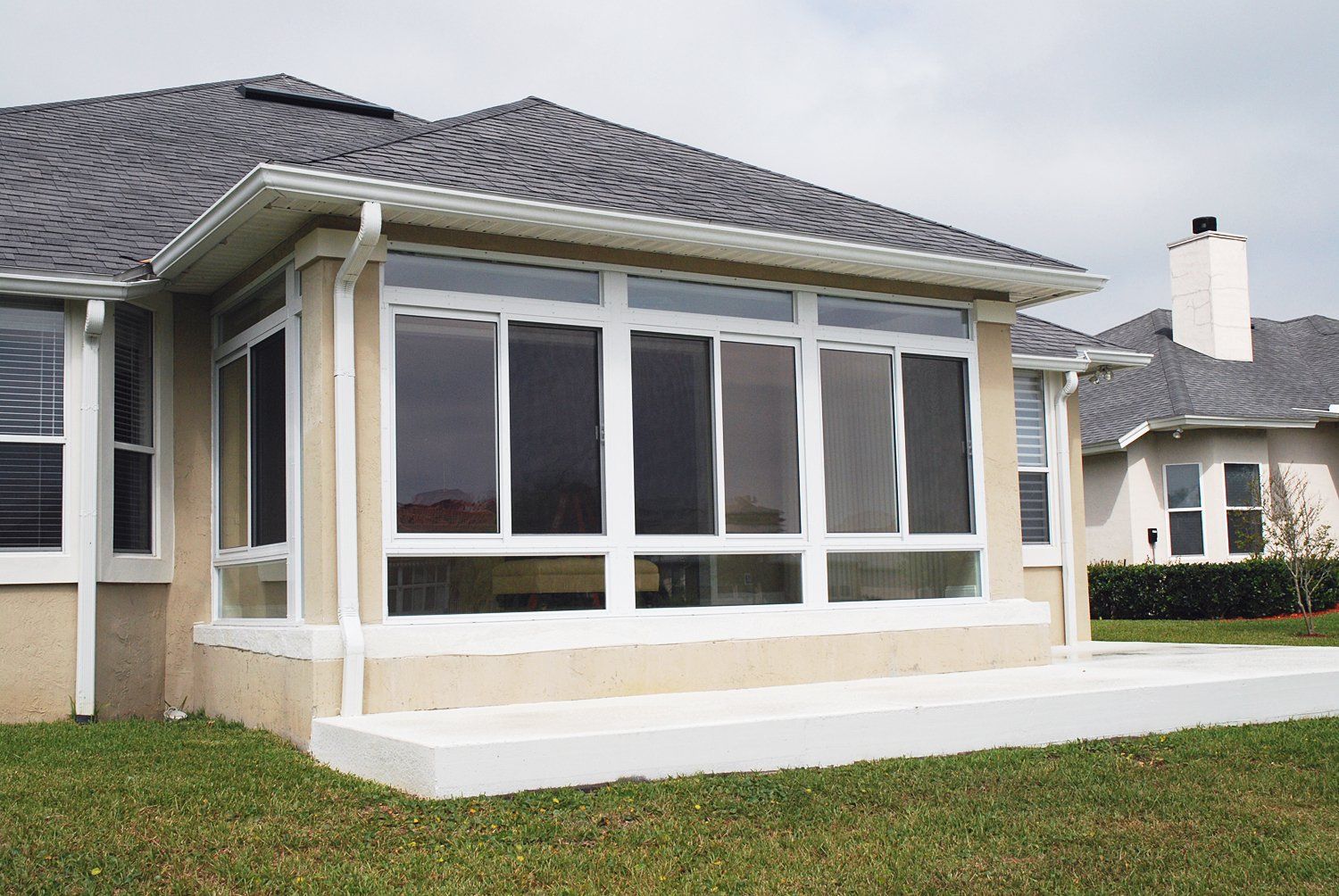 A house with a screened in porch and a gray roof