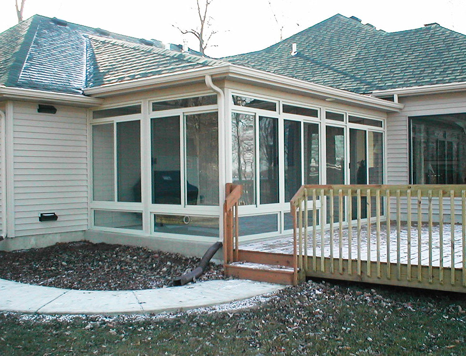 A house with a screened in porch and a wooden deck