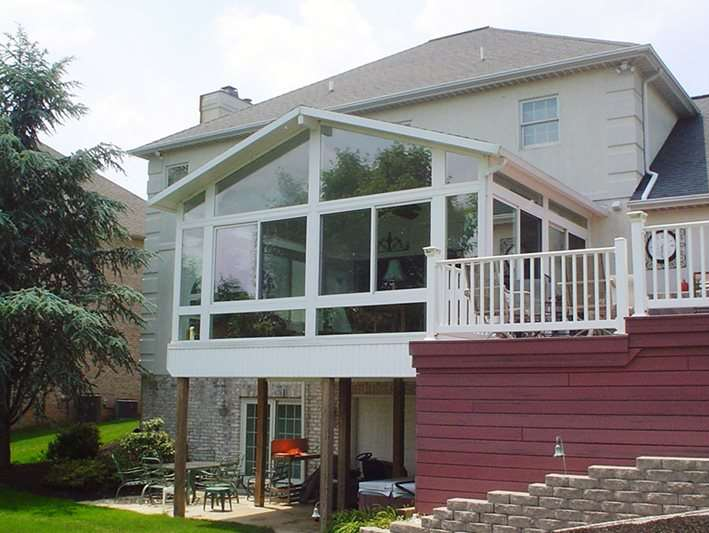 A house with a large sunroom and a balcony