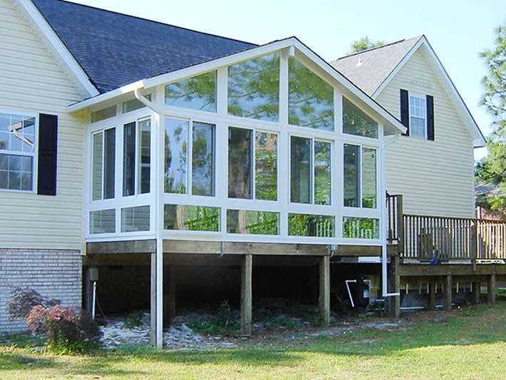 A house with a screened in porch and a deck