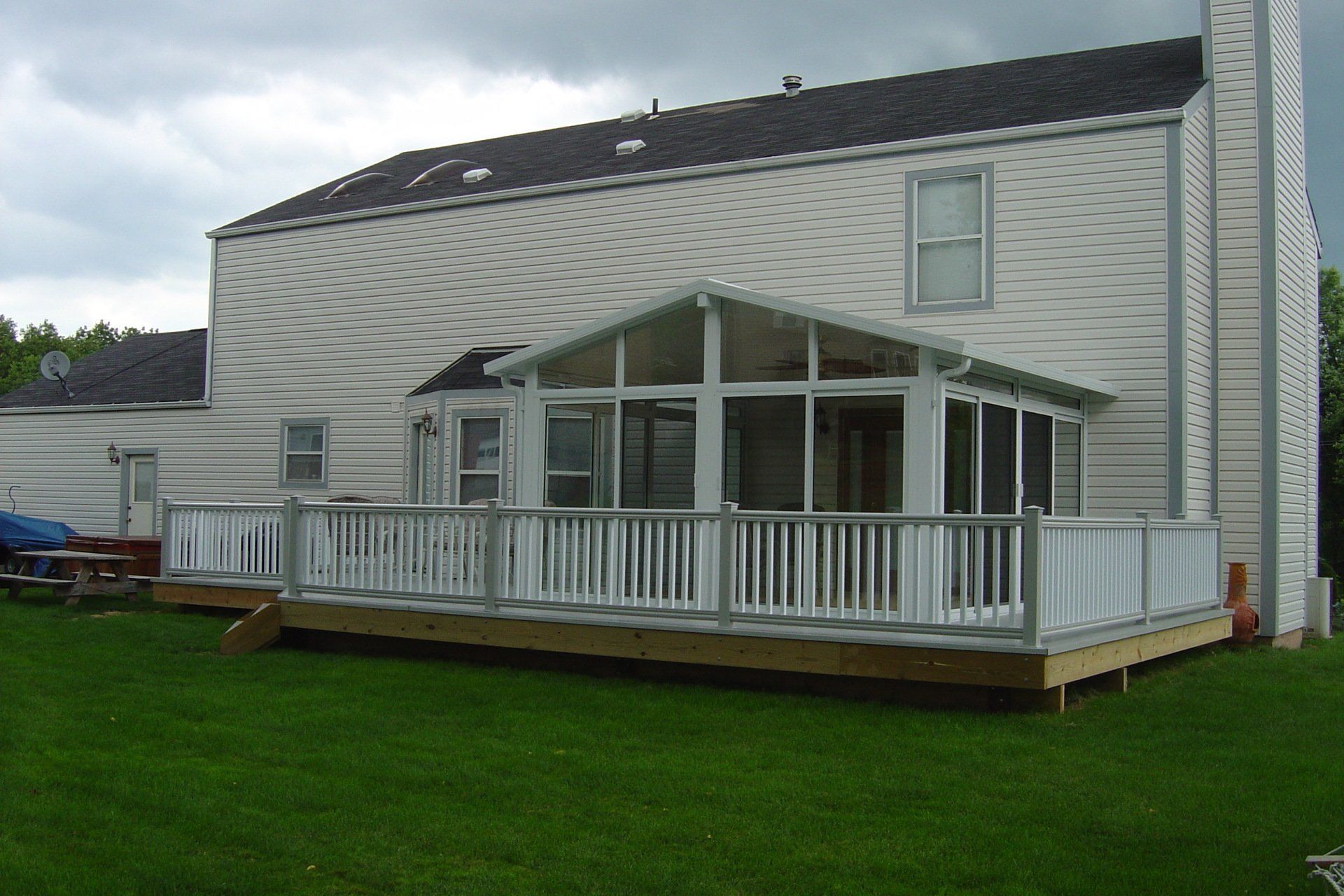A white house with a large screened in porch