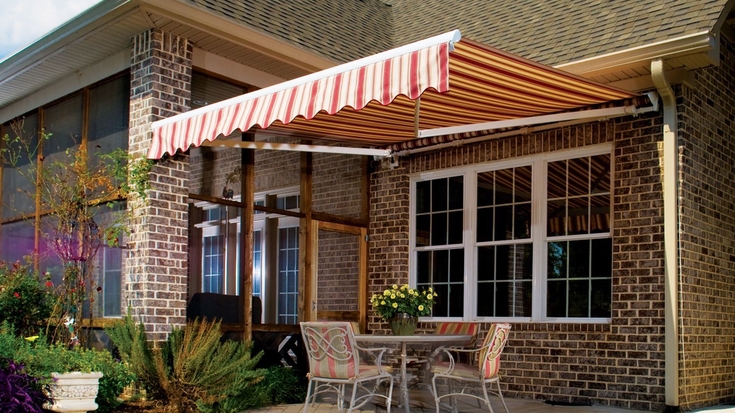 A brick house with a table and chairs under an awning