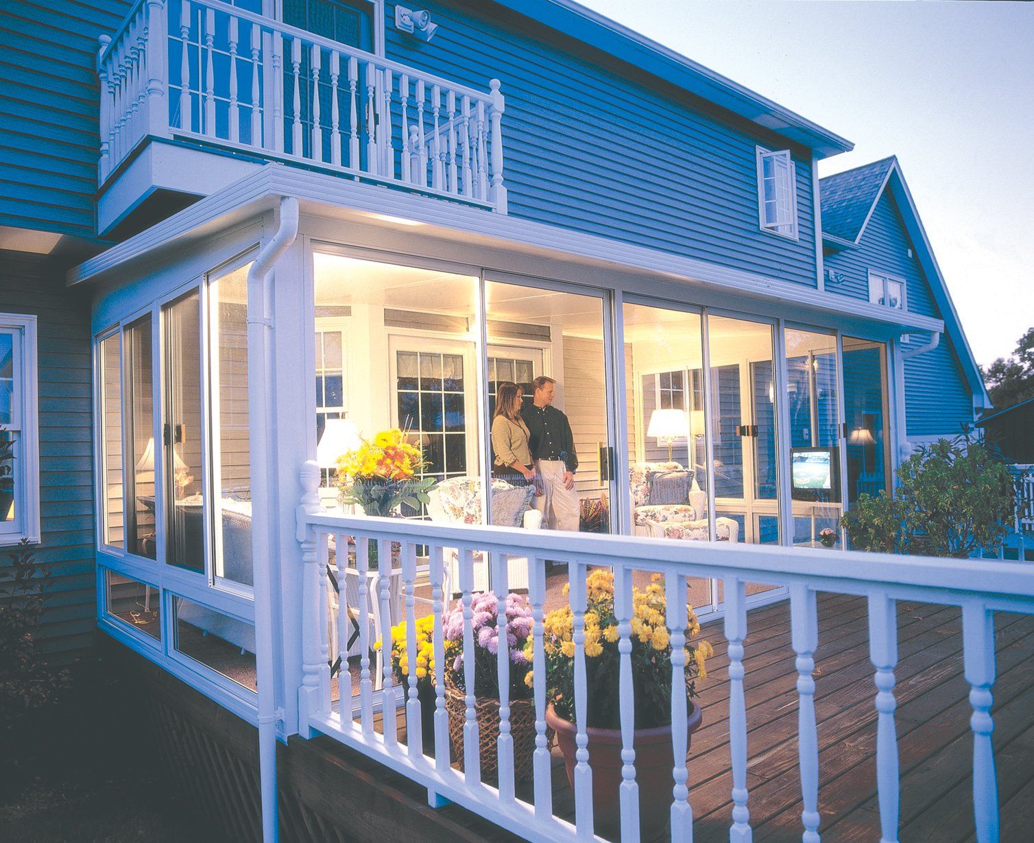 A blue house with a white porch and a balcony