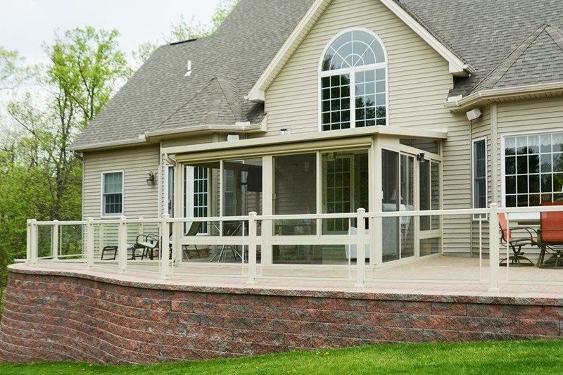 A house with a screened in porch and a brick wall