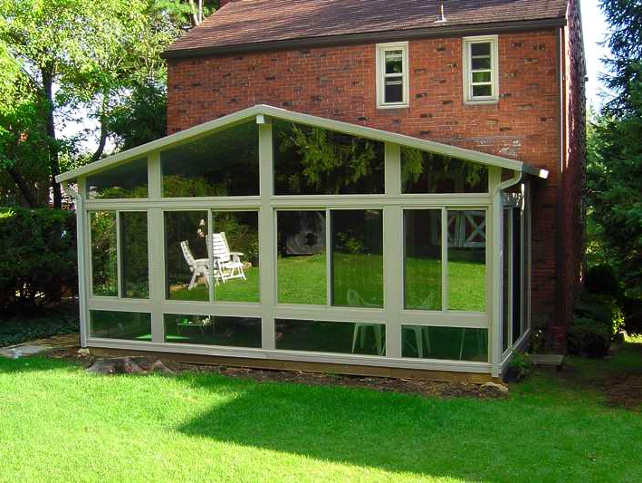 A brick house with a screened in porch in front of it