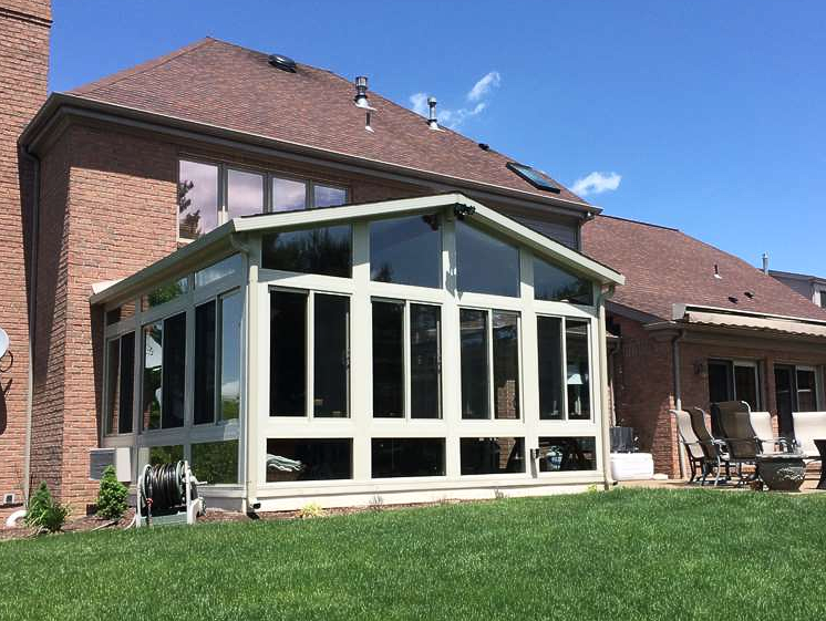 A large house with a sunroom in the backyard