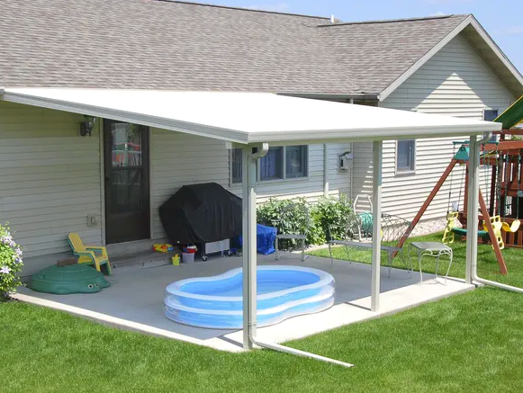 A covered patio with a small pool underneath it