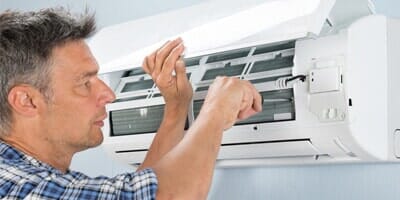 Staff checking air conditioner — Air Conditioning Contractors in Rushville, IN