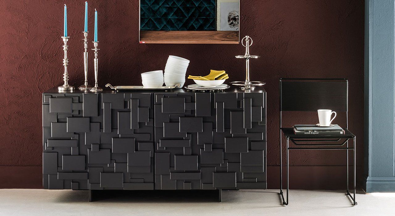 Cattelan Italia Labyrinth Sideboard, a wooden sideboard with doors in 2 finishes and painted stainless steel legs in a dining space.