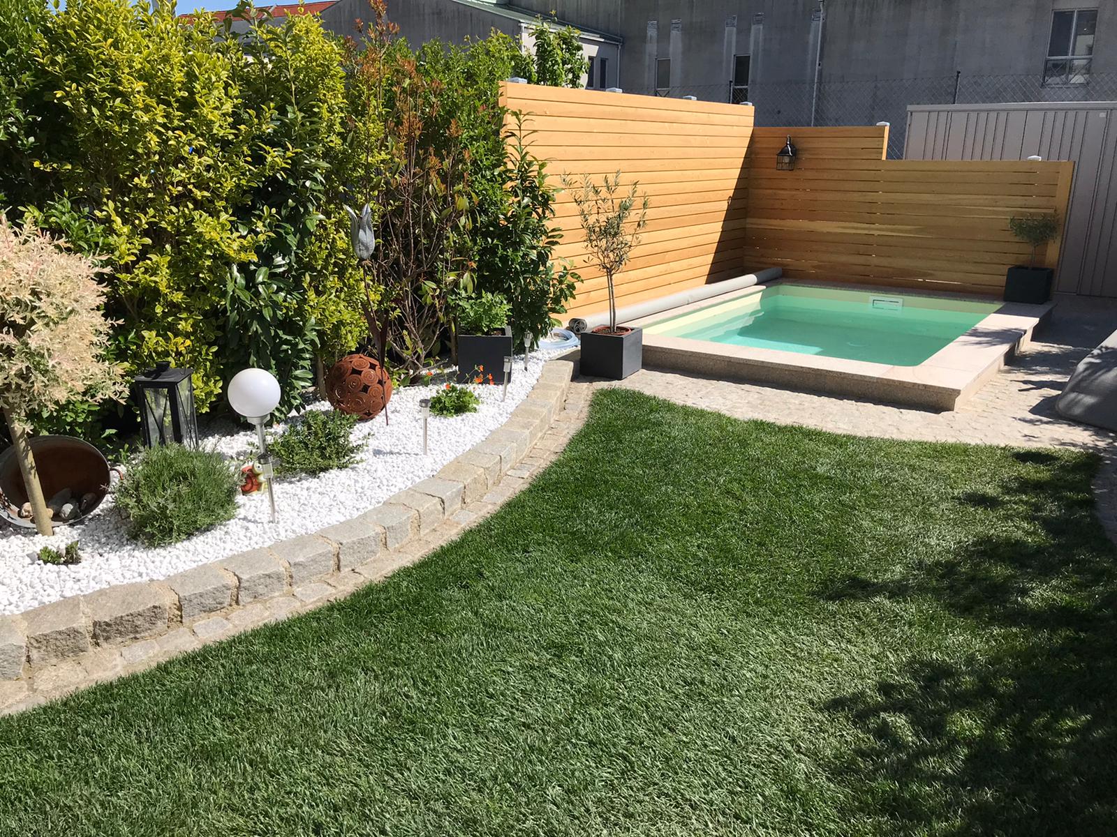Hinterhof mit grünem Rasen, Hochbeet und kleinem Pool mit blickdichtem Holzzaun