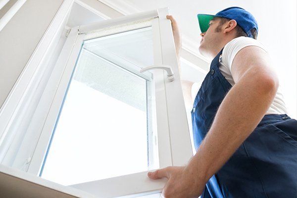 Replacement Windwos — Man Attaching New Glass Window in Newburgh, NY Replacement Windwos — Man Attaching New Glass Window in Newburgh, NY