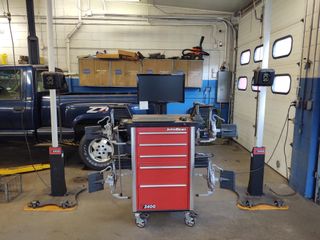 Mechanic examining under hood of car - Alignments in Worcester, MA