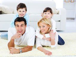 “Family relaxing on freshly cleaned carpet after professional carpet cleaning service.”